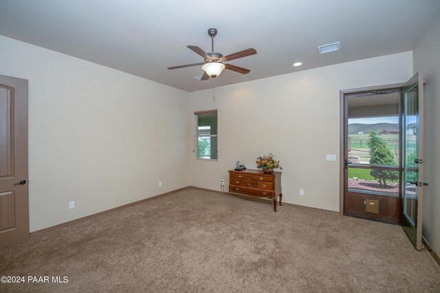 unfurnished room with light carpet and ceiling fan