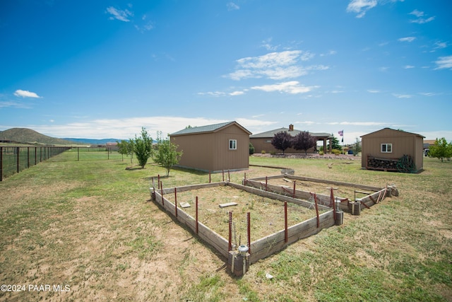 view of yard featuring a mountain view, a rural view, and a storage shed