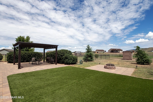 view of yard featuring a storage shed, a pergola, an outdoor fire pit, and a patio