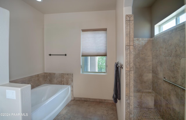 bathroom with a washtub and tile patterned floors