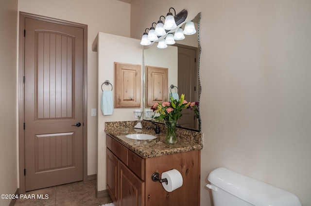 bathroom featuring tile patterned flooring, vanity, and toilet