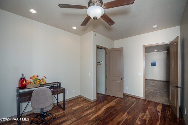 home office with ceiling fan and dark hardwood / wood-style flooring