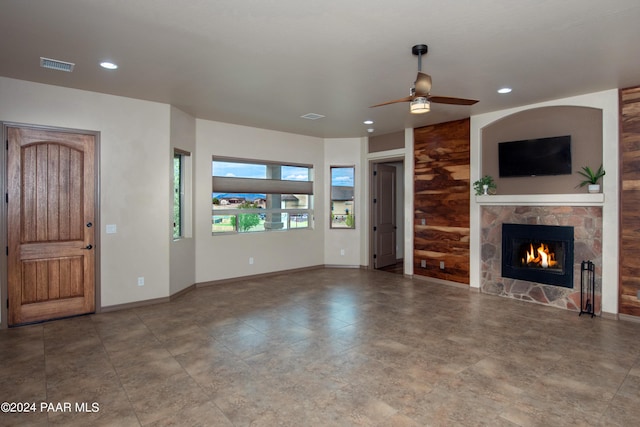 unfurnished living room featuring ceiling fan and a fireplace