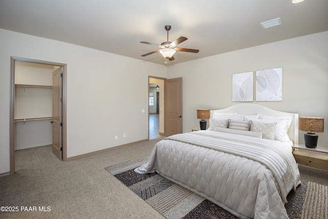 bedroom featuring carpet flooring, a walk in closet, ceiling fan, and a closet