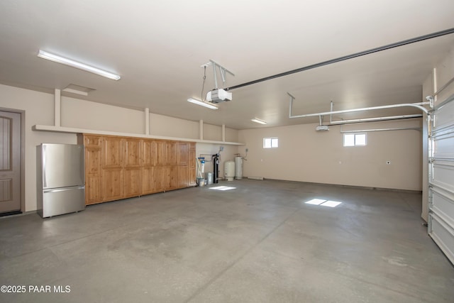 garage featuring a garage door opener and stainless steel refrigerator