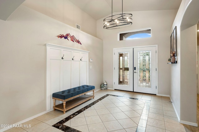 mudroom featuring french doors, light tile patterned flooring, a chandelier, and high vaulted ceiling