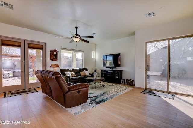 living room featuring ceiling fan, french doors, and light wood-type flooring