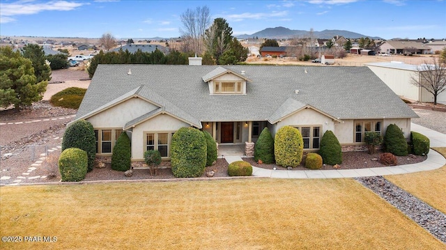 view of front facade featuring a mountain view and a front lawn