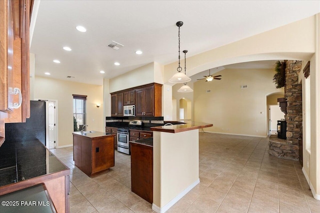 kitchen featuring sink, hanging light fixtures, kitchen peninsula, ceiling fan, and stainless steel appliances