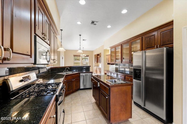 kitchen with pendant lighting, sink, a kitchen island, and appliances with stainless steel finishes