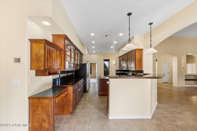 kitchen with pendant lighting, light tile patterned floors, kitchen peninsula, and appliances with stainless steel finishes