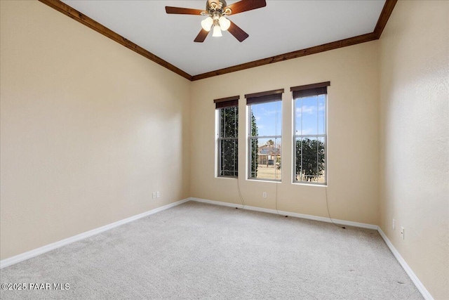 empty room with ornamental molding, carpet, and ceiling fan