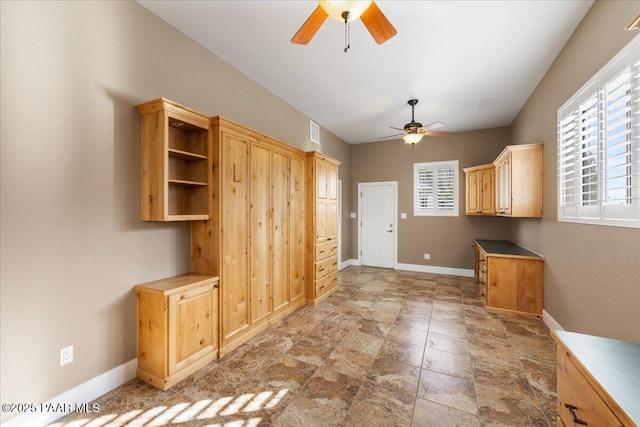 interior space featuring light brown cabinets and ceiling fan