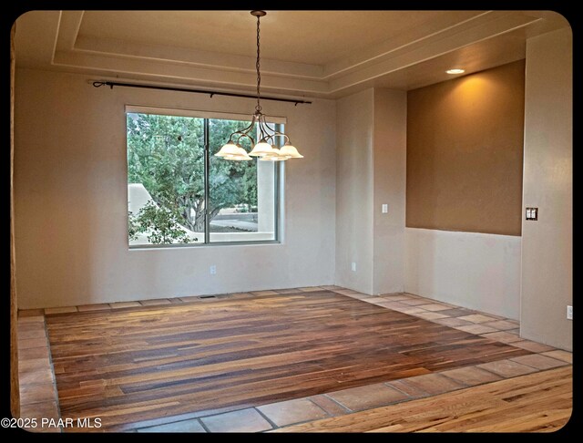 10614 E High Point Dr, Dewey-Humboldt, AZ 86327 - unfurnished dining area with a tray ceiling, wood finished floors, and a chandelier