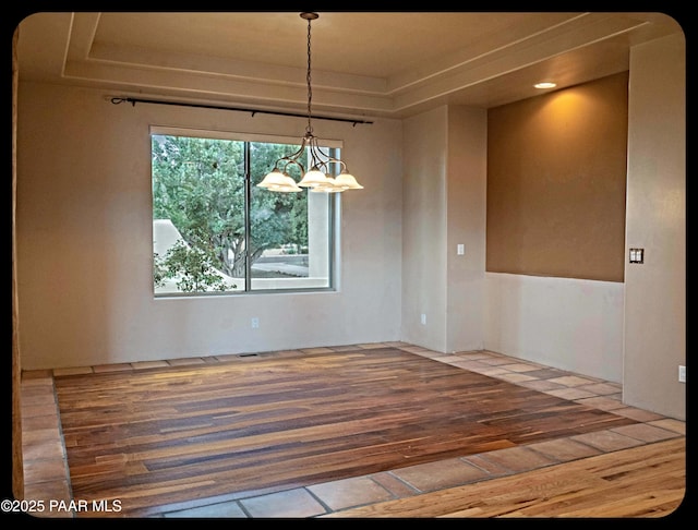 10614 E High Point Dr, Dewey-Humboldt, AZ 86327 - unfurnished dining area with wood-type flooring, a tray ceiling, and a chandelier