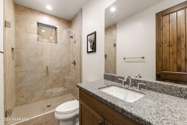 bathroom featuring tile patterned flooring, vanity, toilet, and an enclosed shower