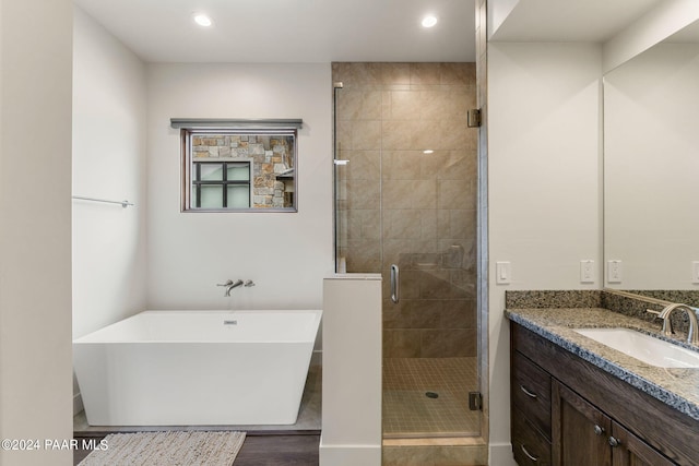 bathroom with vanity, wood-type flooring, and independent shower and bath