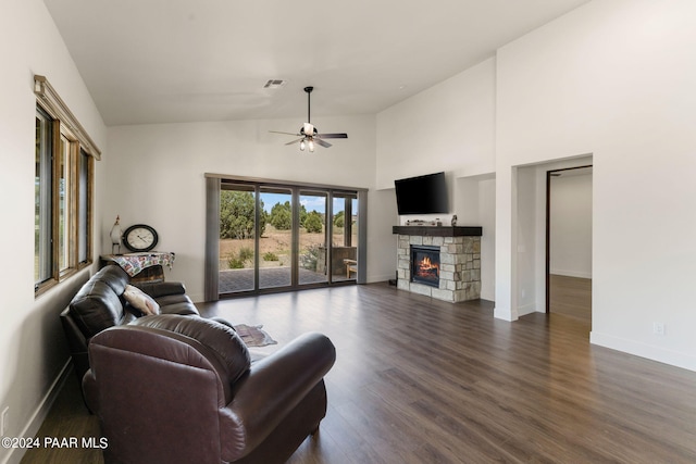 living room with a stone fireplace, ceiling fan, high vaulted ceiling, and dark hardwood / wood-style floors