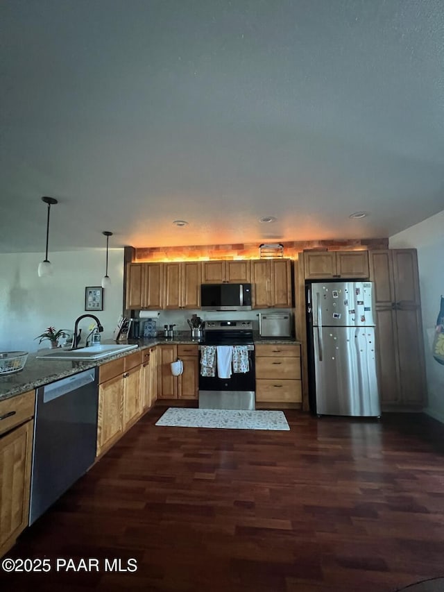 kitchen featuring hanging light fixtures, dark hardwood / wood-style floors, sink, and appliances with stainless steel finishes