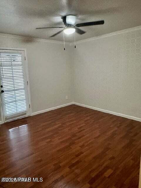 unfurnished room with crown molding, dark hardwood / wood-style flooring, and a textured ceiling