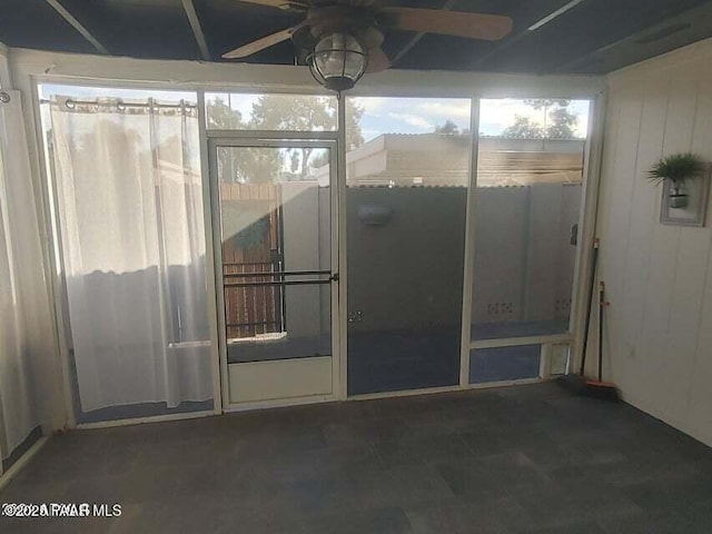 unfurnished sunroom with ceiling fan