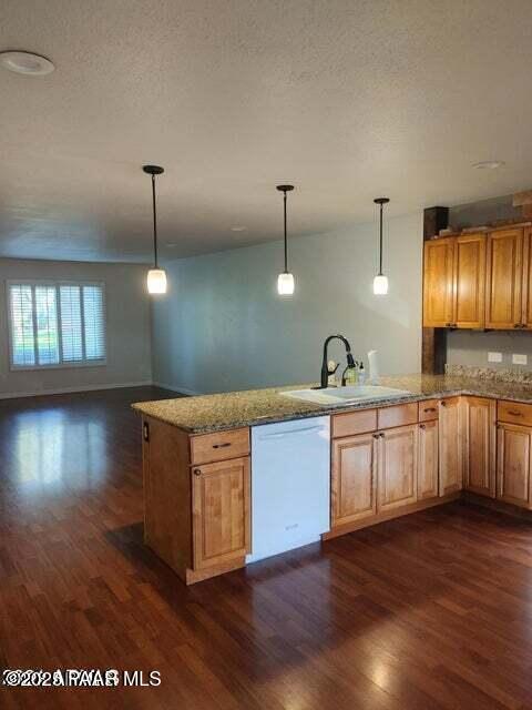 kitchen featuring sink, dark hardwood / wood-style floors, white dishwasher, kitchen peninsula, and pendant lighting