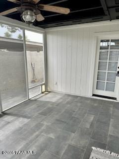 unfurnished sunroom with ceiling fan