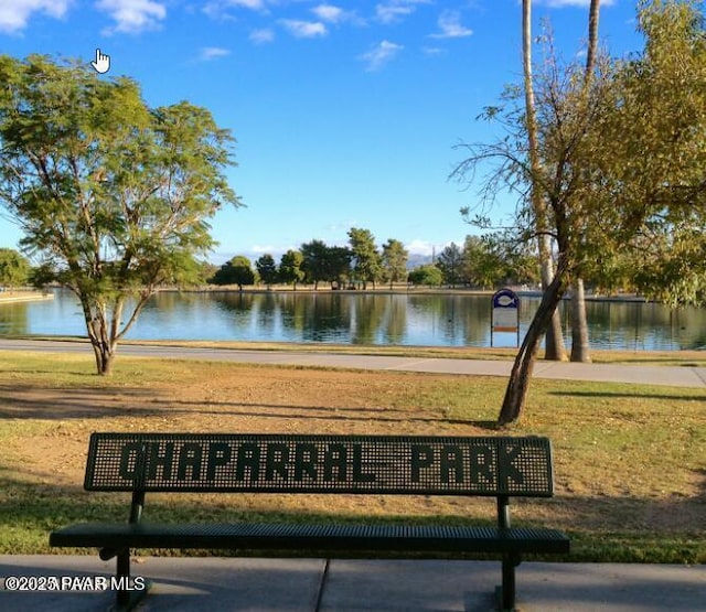 surrounding community with a yard and a water view