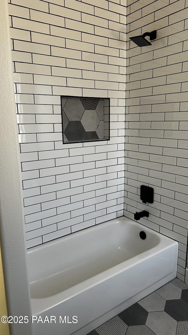 bathroom featuring tile patterned floors and tiled shower / bath