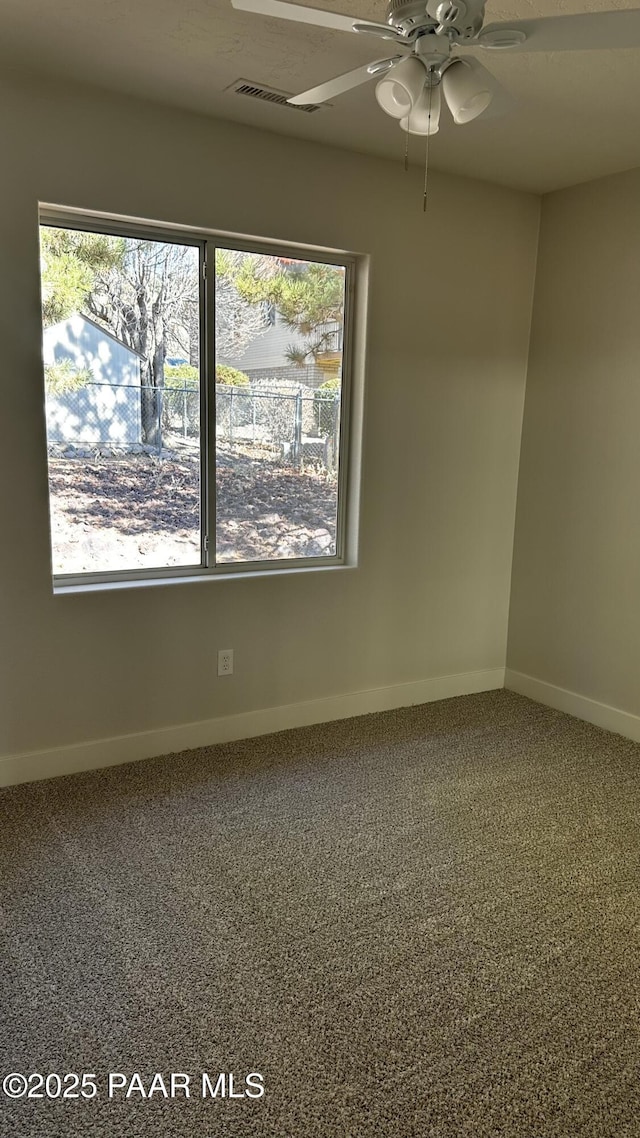 spare room featuring ceiling fan and carpet