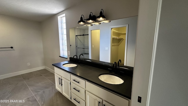 bathroom featuring a textured ceiling, a shower, tile patterned floors, and vanity