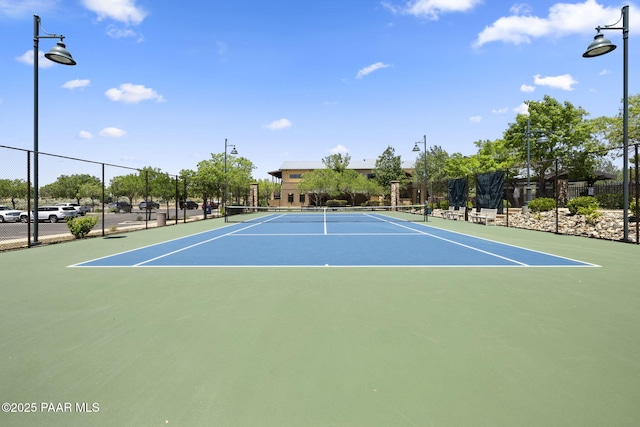 view of tennis court with community basketball court and fence