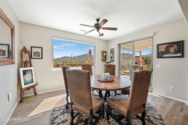 dining area with visible vents, baseboards, light wood-style floors, and a ceiling fan