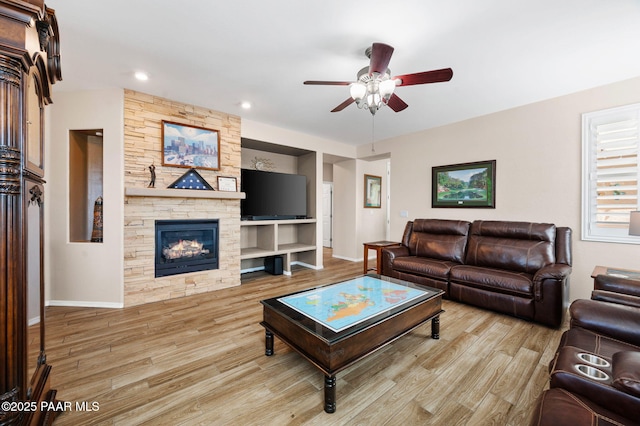 living room featuring wood finished floors, baseboards, a fireplace, recessed lighting, and ceiling fan