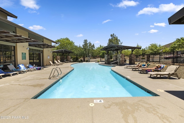 community pool featuring fence and a patio area