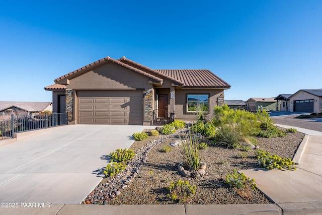 view of front of house with stucco siding, stone siding, concrete driveway, an attached garage, and a tiled roof