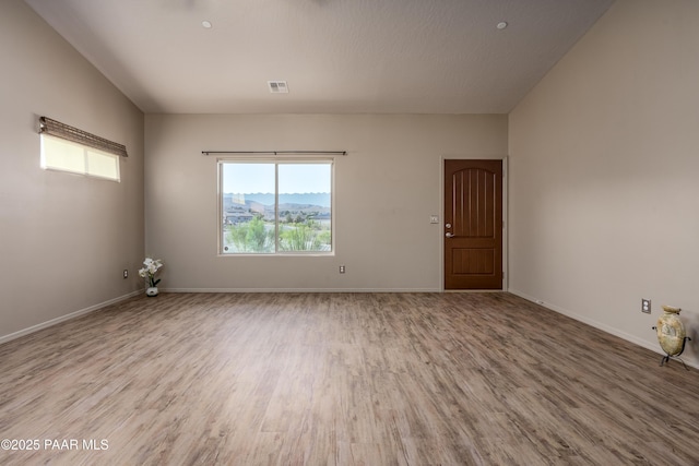 spare room featuring visible vents, wood finished floors, and baseboards