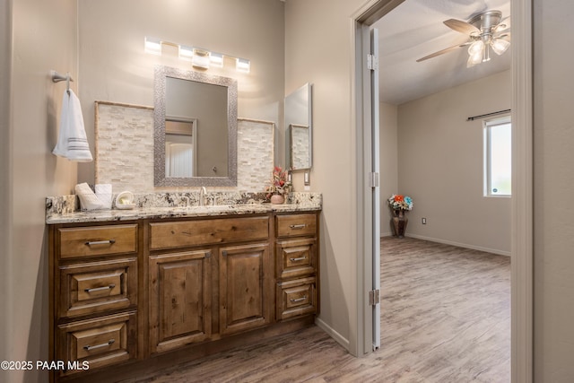 bathroom with vanity, wood finished floors, baseboards, and ceiling fan