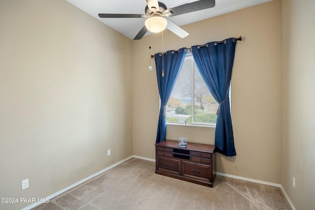 carpeted spare room featuring ceiling fan