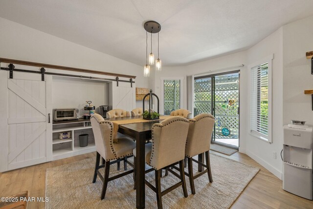 4361 N Covina Cir, Prescott Valley, AZ 86314 - dining area with a barn door, light wood-style flooring, and baseboards