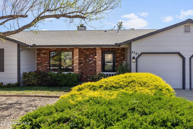 4361 N Covina Cir, Prescott Valley, AZ 86314 - single story home featuring a garage, brick siding, a chimney, and roof with shingles