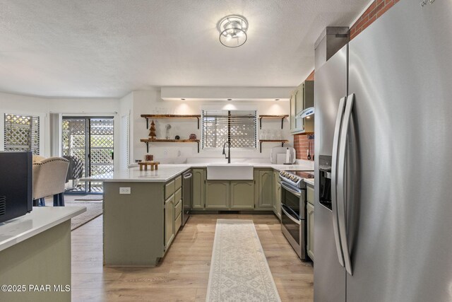 4361 N Covina Cir, Prescott Valley, AZ 86314 - kitchen featuring stainless steel appliances, green cabinets, open shelves, light countertops, and a sink