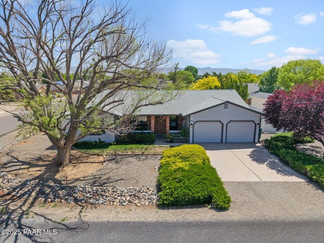 4361 N Covina Cir, Prescott Valley, AZ 86314 - ranch-style house with an attached garage, concrete driveway, a porch, and a mountain view