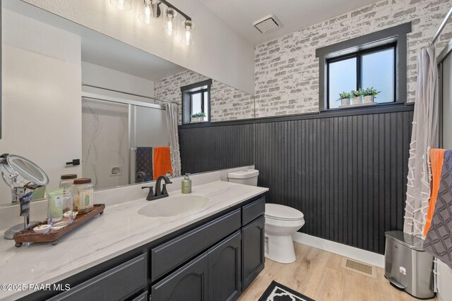 4361 N Covina Cir, Prescott Valley, AZ 86314 - full bath with wainscoting, a shower stall, wood finished floors, vanity, and toilet