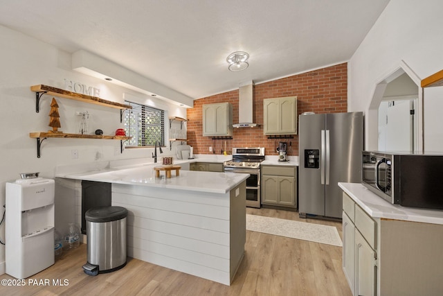 4361 N Covina Cir, Prescott Valley, AZ 86314 - kitchen featuring stainless steel appliances, wall chimney exhaust hood, a peninsula, light wood-style floors, and vaulted ceiling