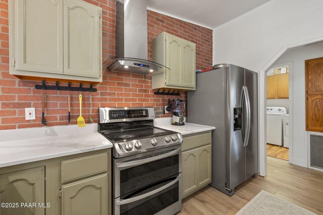 4361 N Covina Cir, Prescott Valley, AZ 86314 - kitchen with appliances with stainless steel finishes, wall chimney range hood, light wood finished floors, backsplash, and independent washer and dryer