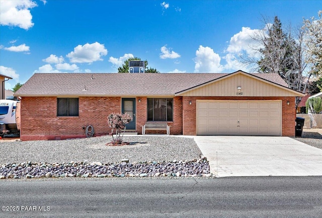 single story home with central air condition unit, a garage, concrete driveway, and brick siding