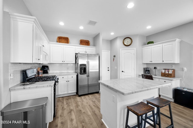 kitchen with a kitchen island, white cabinetry, and stainless steel appliances