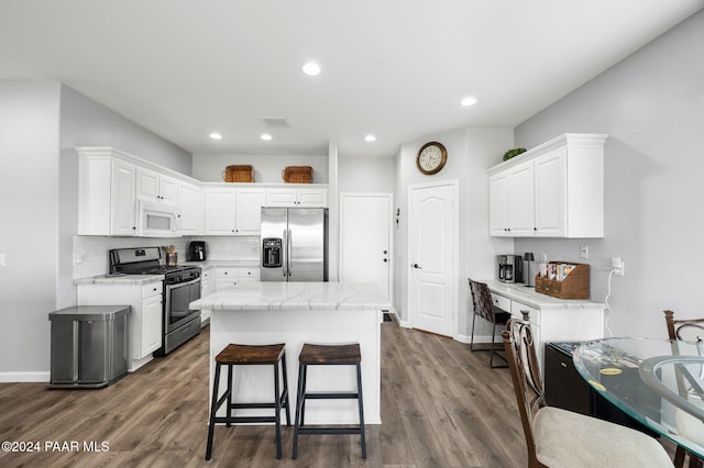 kitchen featuring a center island, white cabinets, decorative backsplash, dark hardwood / wood-style flooring, and stainless steel appliances