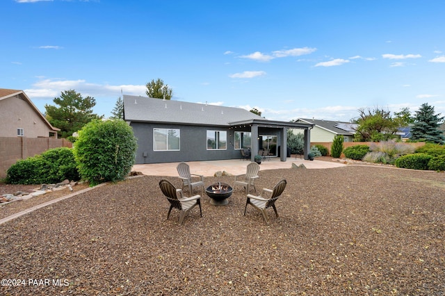 rear view of house featuring a patio and a fire pit